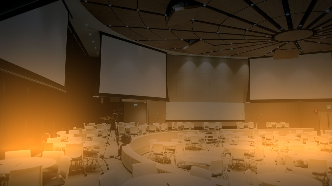 The same conference room with warm amber uplighting along the walls