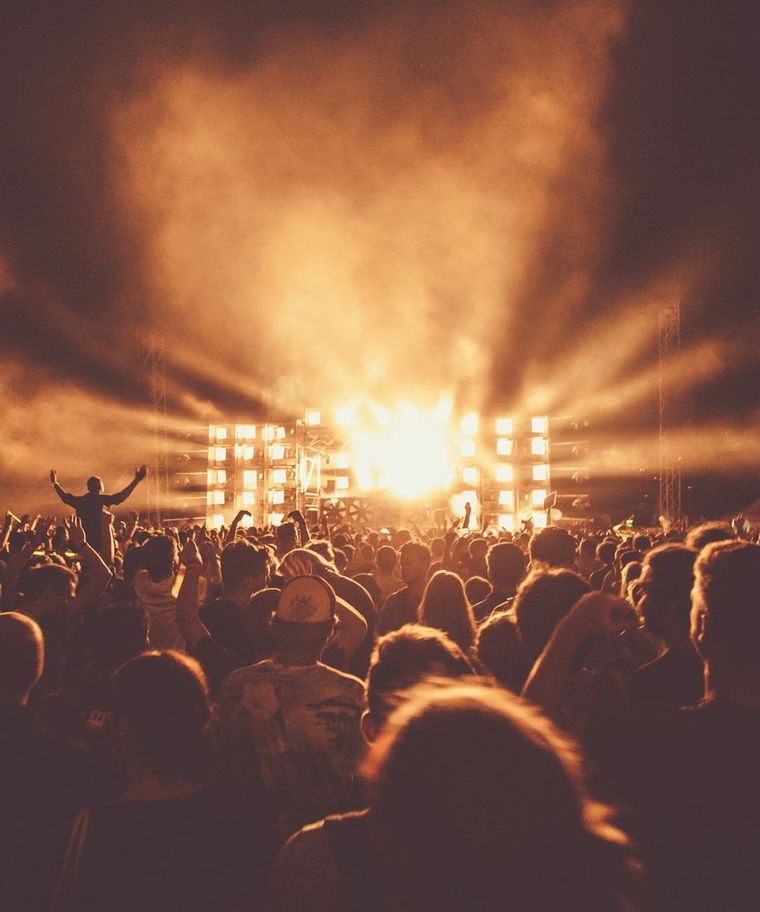 Stage lighting beams cutting through haze at a live event